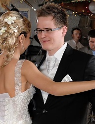 Ślubne upięcie z blond włosów z wpiętymi kwiatami
