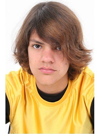 Close up of teen boy in yellow shirt. Serious expression.