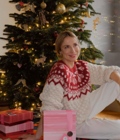 Natalia Klimas-Bober w świątecznej stylizacji pozuje na tle choinki.